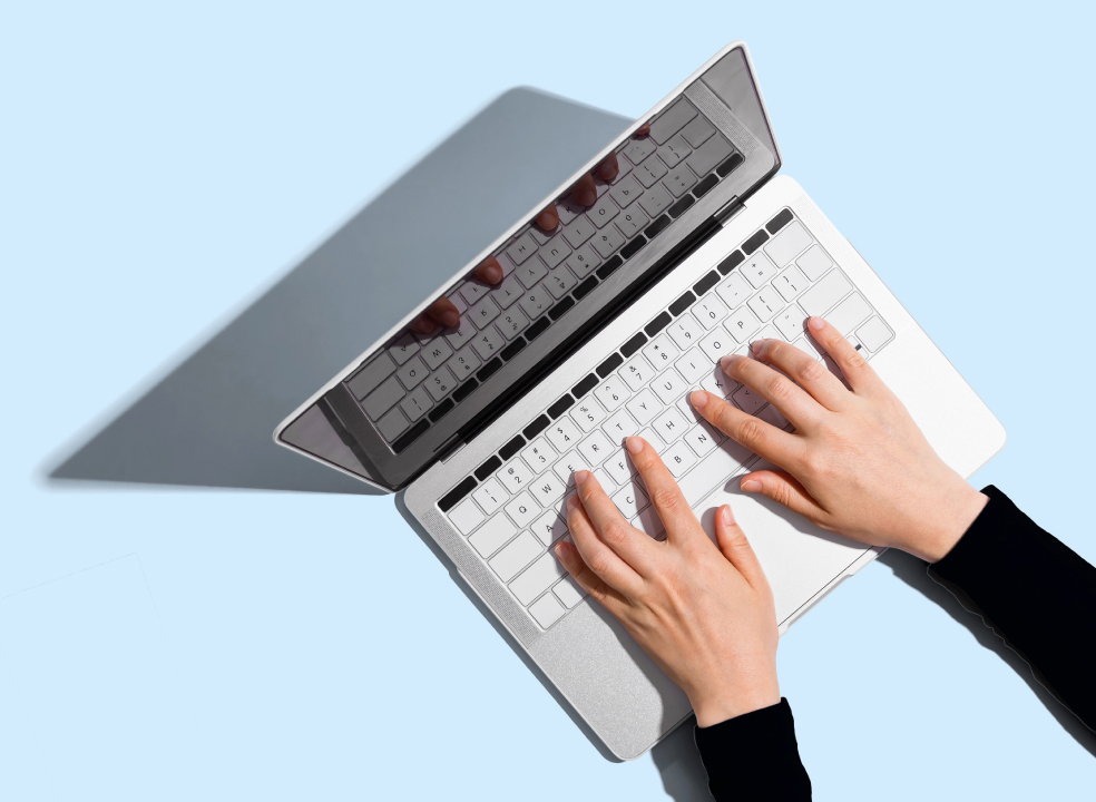 Hände tippen auf der Tastatur eines Laptops